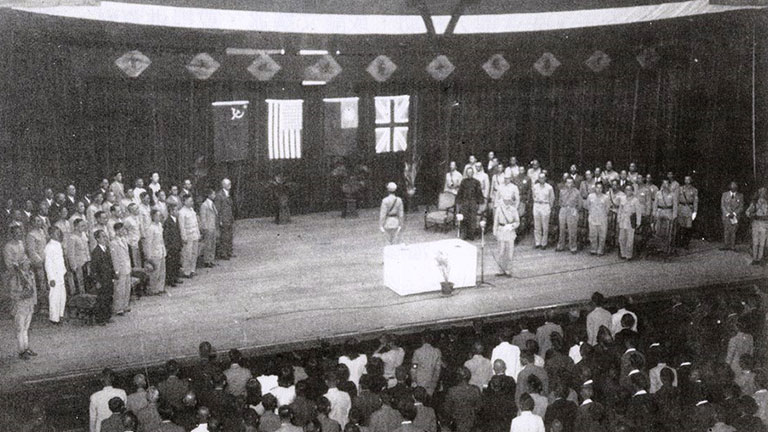 受降典禮現場，牆上由左至右可見蘇聯、美國、中華民國、英國等4國童盟國的國旗。圖／取自維基百科